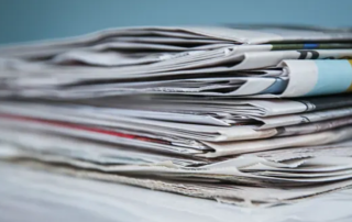 stacked newsprint sections folded showing colored edges